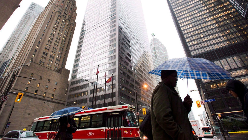 A man carries an umbrella through downtown Toronto during a rainstorm in this file photo. (Nathan Denette/The Canadian Press)