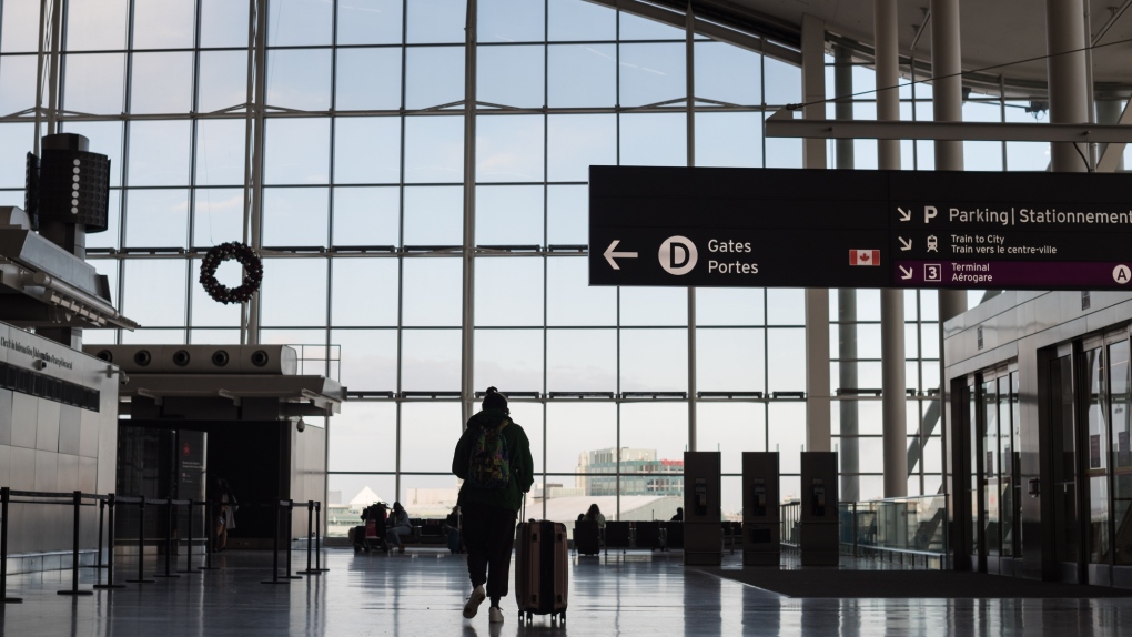 Travellers are photographed at Toronto Pearson International Airport, on Thursday, December 16, 2021.  THE CANADIAN PRESS/Tijana Martin