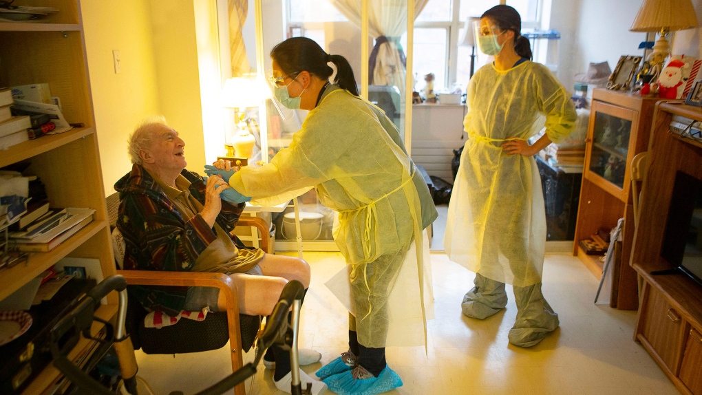 Personal support workers Ana Nguyen, centre, and Olivia Proudfoot tend to Israel Gorlick at Springhurst Manor, part of Parkdale  Assisted Living, a programme run by West Neighbourhood House, in Toronto, Friday, Dec. 4, 2020. THE CANADIAN PRESS/Chris Young