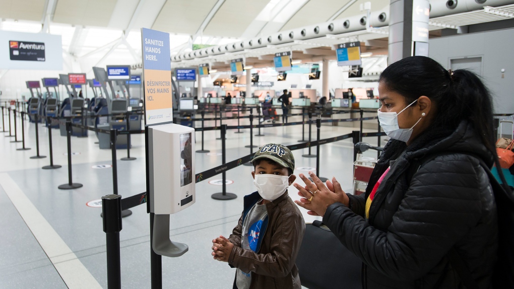 People use mandatory hand sanitizer and masks at Toronto's Pearson International Airport for a "Healthy Airport" during the COVID-19 pandemic in Toronto on Tuesday, June 23, 2020. THE CANADIAN PRESS/Nathan Denette