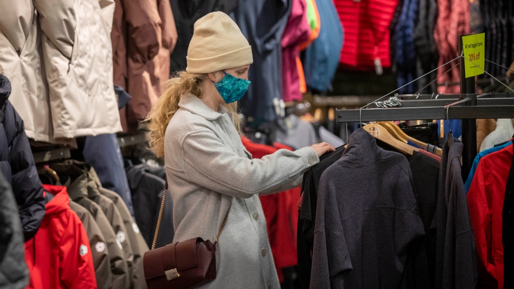 Erin Connolly wears a mask to protect them from the COVID-19 virus while looking at clothes at Trailhead in Kingston, Ontario, on Wednesday Feb. 10, 2021. . THE CANADIAN PRESS/Lars Hagberg 