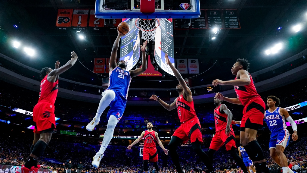Philadelphia 76ers' Joel Embiid, center left, goes up for the shot against the Toronto Raptors during the first half of Game 1 of an NBA basketball first-round playoff series, Saturday, April 16, 2022, in Philadelphia. (AP Photo/Chris Szagola) 