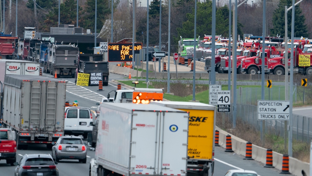 FILE - Dump truck drivers seen on the east and westbound QEW near Third Line in Oakville, Ont. on Thursday, April 15, 2021.The Canadian Press/Peter Power 