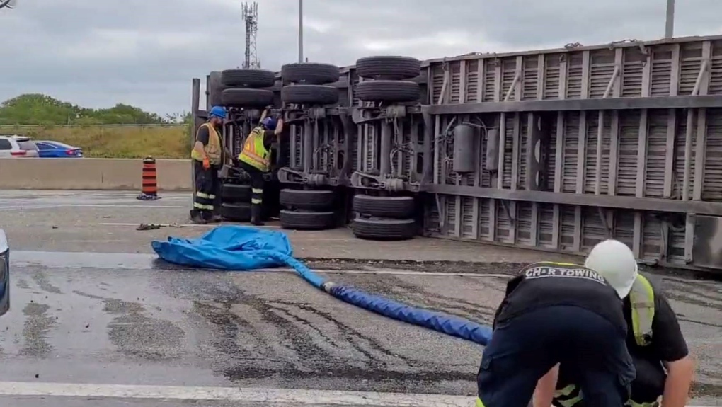 A transport truck is shown on its side on the Queen Elizabeth Way in Oakville on Tuesday morning following a rollover. 