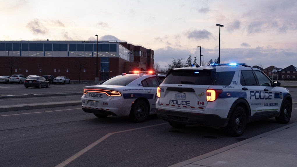 Police cars are pictured at the scene of a shooting at Castlebrooke Secondary School in Brampton, Ont., on Friday, Nov. 18, 2022. A union representing high school teachers in Ontario is calling on the province to provide more funding for training programs and hiring more mental health support staff to address a recent rise in violence in and around schools. THE CANADIAN PRESS/Arlyn McAdorey