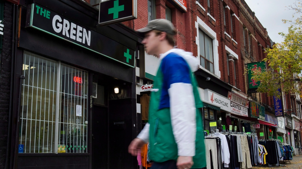 People walk past a cannabis dispensary in Toronto on Monday, October 15, 2018. (THE CANADIAN PRESS/Christopher Katsarov)