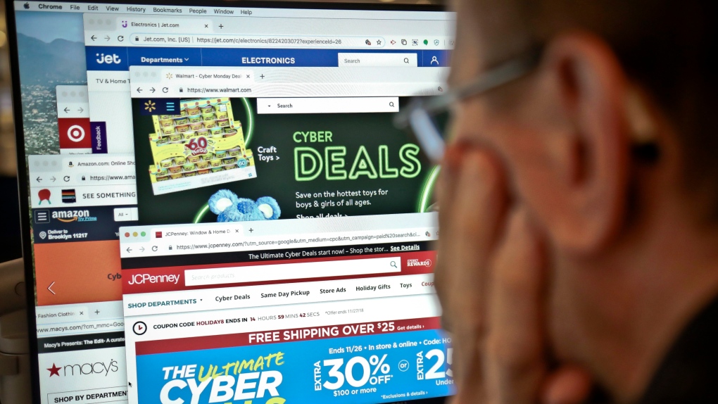 A journalist looks at a computer screen with webpages arranged to show Cyber Monday deals by various online retailers Monday Nov. 26, 2018, in New York. (AP Photo/Bebeto Matthews)