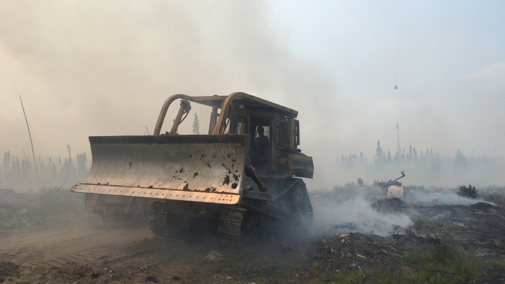 A bulldozer clears debris as crews battle a forest fire near Pikangikum First Nation, Ont. in this undated handout photo. (Ontario Ministry of Natural Resources and Forestry )