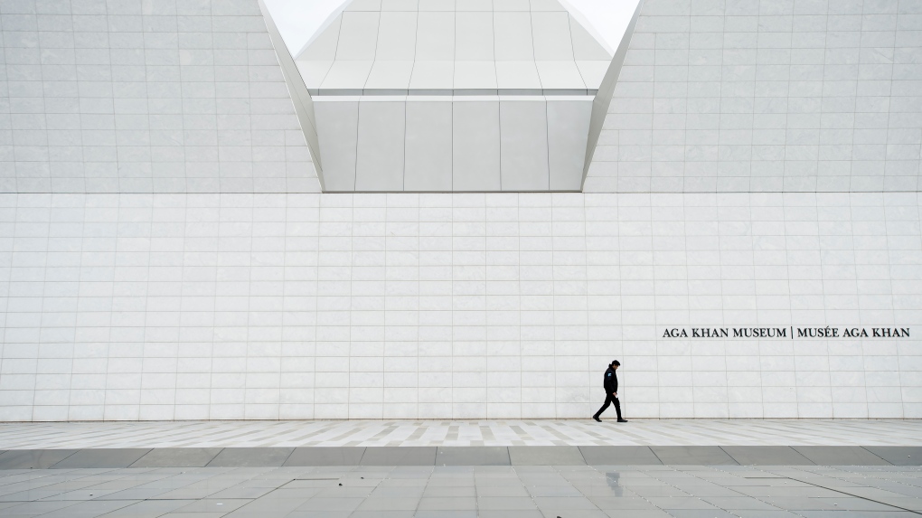 A lone security guard patrols an empty and closed Aga Khan Museum in Toronto on Friday, April 24, 2020. Health officials and the government have asked that people stay inside to help curb the spread of COVID-19 pandemic. THE CANADIAN PRESS/Nathan Denette 
