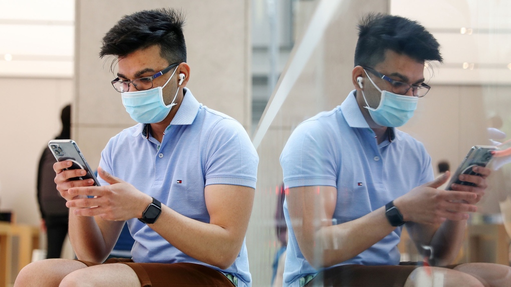  A customer wearing a protective mask tries out an iPhone 12 Pro Max at the Apple flagship store. (Brendon Thome/Bloomberg/Getty Images/CNN) 