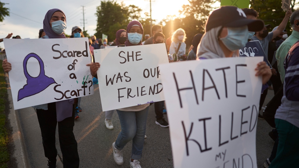 Young women walk with signs in London Ont. on Friday, June 11, 2021 during a Multi-Faith March to End Hatred after four members of a Muslim family were killed on Sunday in what police called a hate crime. THE CANADIAN PRESS/Geoff Robins 
