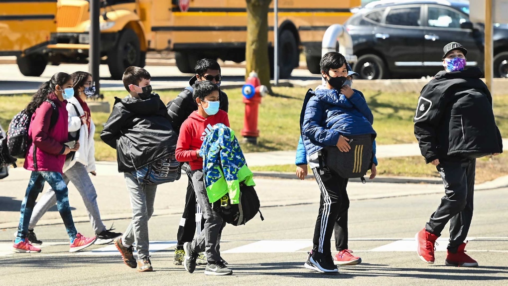 Students cross the street at Tomken Road Middle School as Ontario prepares for its third province wide lockdown during the COVID-19 pandemic in Mississauga, Ont., on Thursday, April 1, 2021. THE CANADIAN PRESS/Nathan Denette