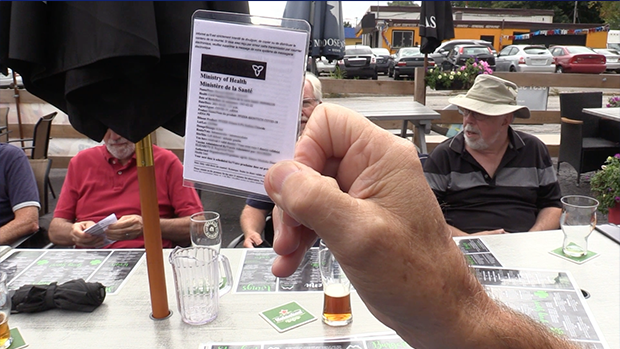 A man holds his COVID-19 vaccine receipt at a restaurant in Barrie, Ont., on Tues., Sept. 21, 2021 (Mike Arsalides/CTV News)