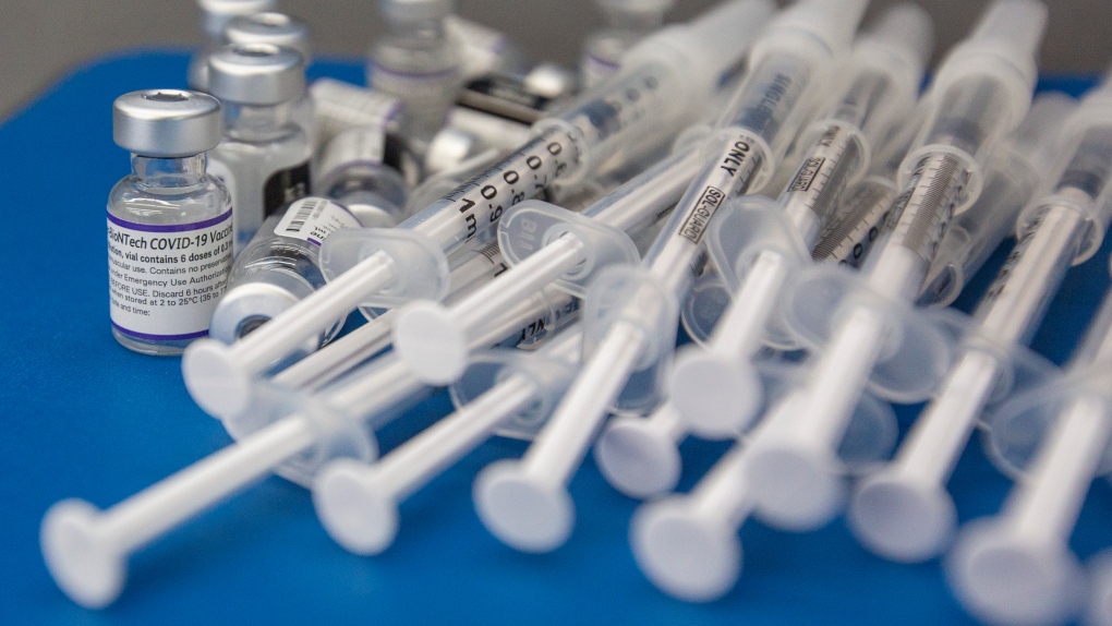 Syringes and vials of Pfizer-BioNTech COVID-19 vaccine are seen on a work surface during a drive through clinic at St. Lawrence College in Kingston, Ont., Saturday, Dec. 18, 2021. THE CANADIAN PRESS/Lars Hagberg