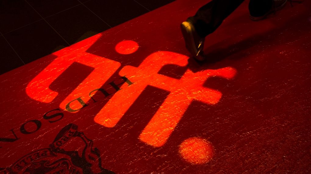 FILE - A man walks on a red carpet displaying a sign for the Toronto International Film Festival at the TIFF Bell Lightbox in Toronto on Wednesday, September 3, 2014. THE CANADIAN PRESS/Darren Calabrese