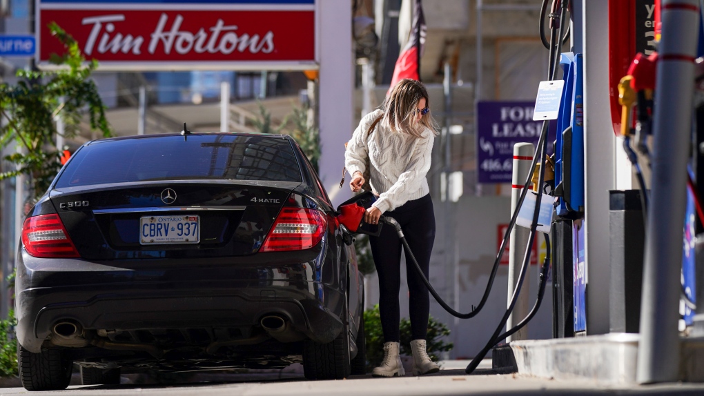 A woman fills her vehicle with fuel during the COVID-19 pandemic in Toronto on Tuesday, October 19, 2021. THE CANADIAN PRESS/Evan Buhler