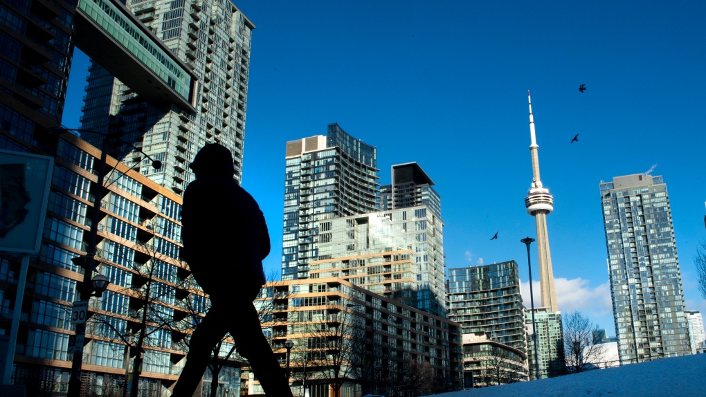 Condo towers dot the Toronto skyline as a pedestrian makes his way through the winter landscape on Thursday January 28, 2021. THE CANADIAN PRESS/Frank Gunn