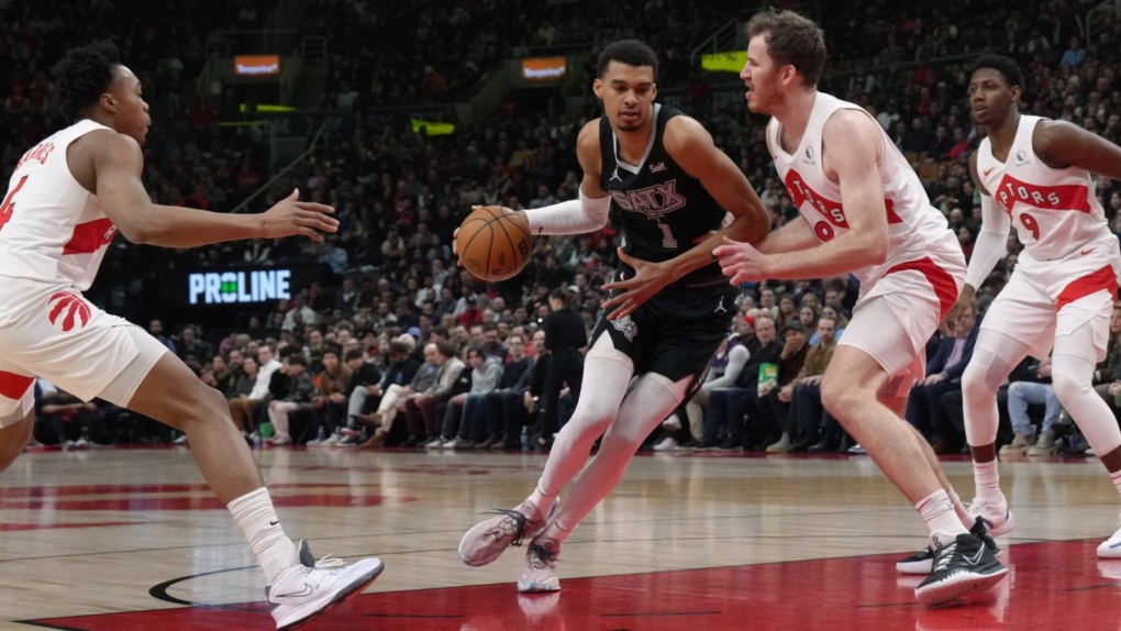 San Antonio Spurs centre Victor Wembanyama (1) drives towards the basket as Toronto Raptors' Jakob Poeltl (19) defends during first half NBA basketball action in Toronto on Monday Feb. 12, 2024. THE CANADIAN PRESS/Chris Young